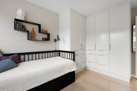 A bedroom with a bed, dresser, and mirror