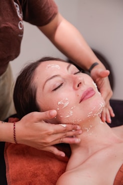 A woman getting a facial mask on her face