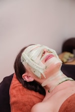 A woman laying down with a mask on her face