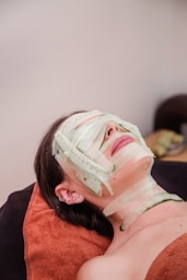 A woman laying down with a mask on her face