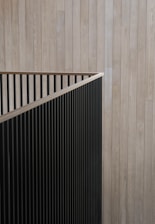 A man in a suit and tie standing in front of a wooden wall