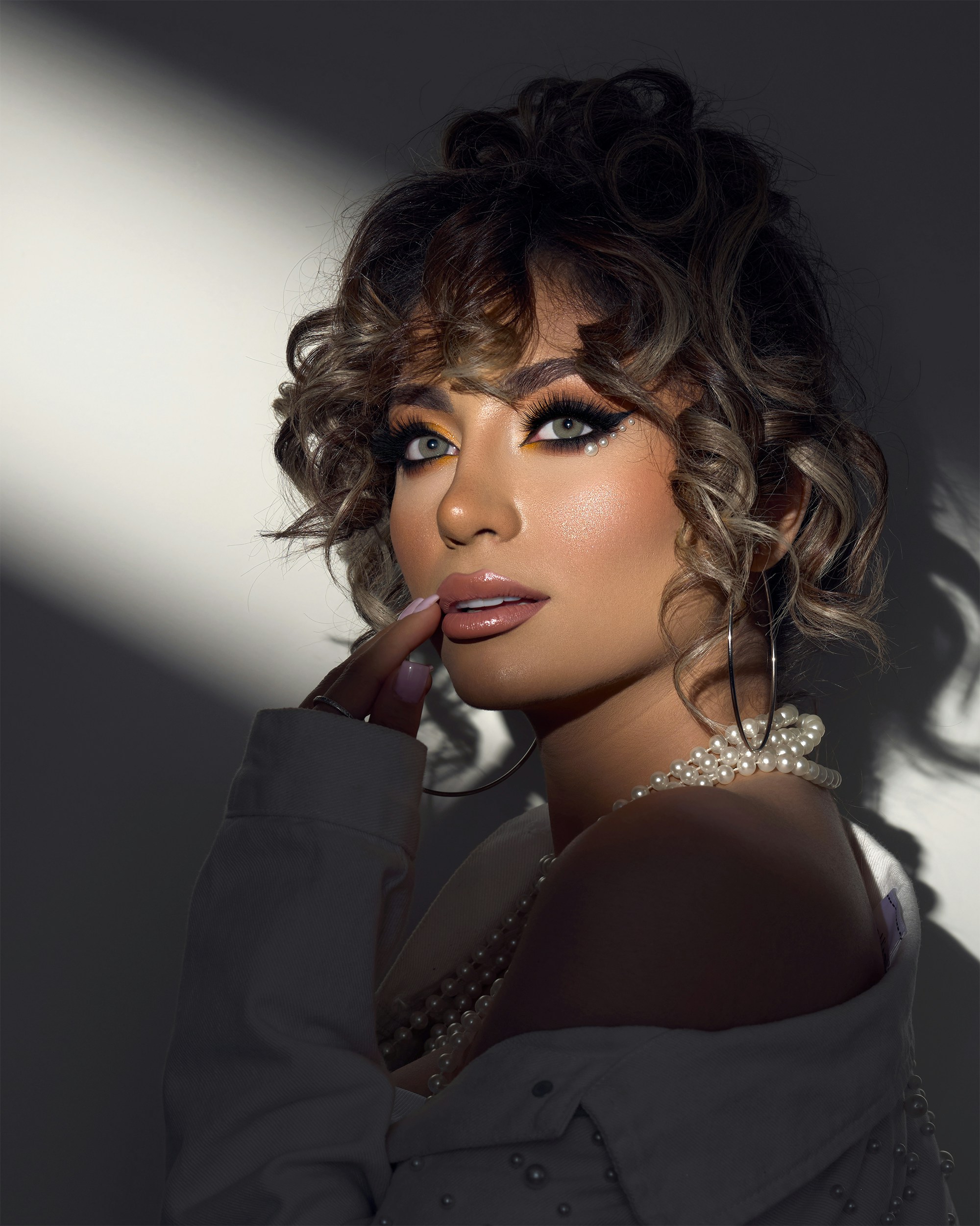 A woman with curly hair posing for a picture