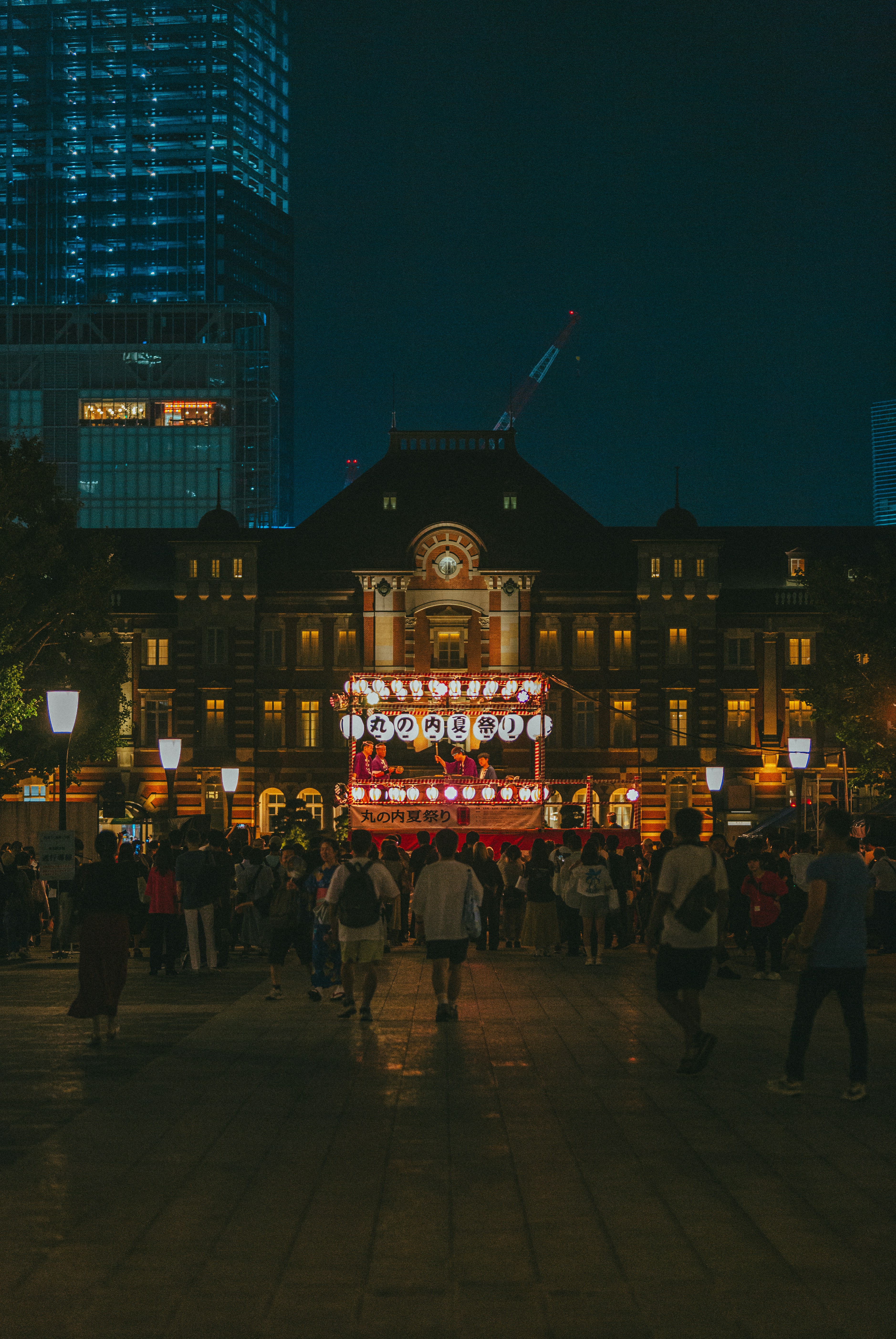 A crowd of people standing around a building at night