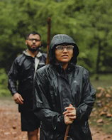 A man in a black raincoat and a man in a black jacket with a