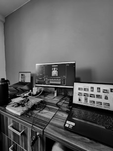 A desk with a laptop and a monitor on it