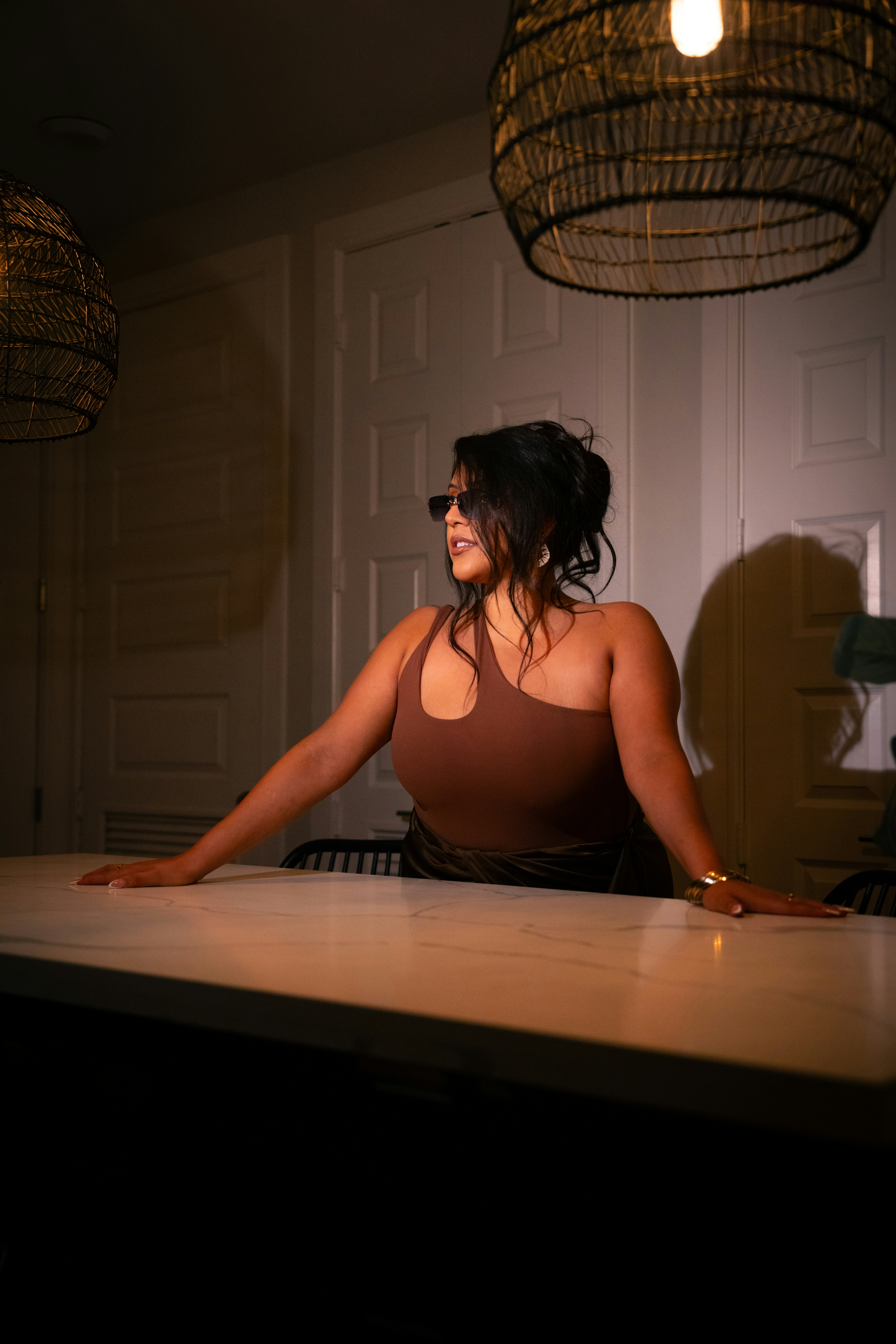 A woman sitting at a counter in a kitchen