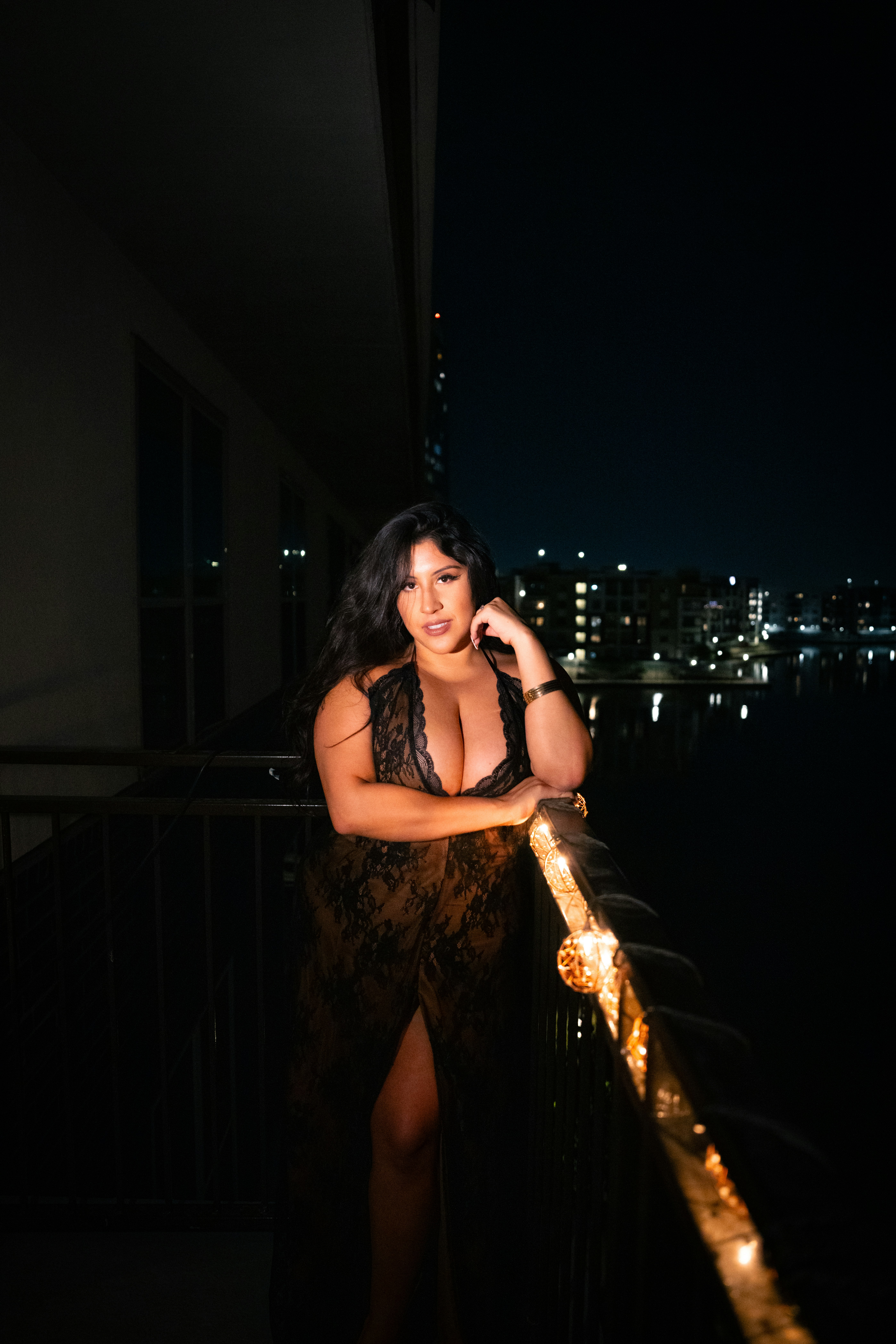 A woman standing on a balcony talking on a cell phone