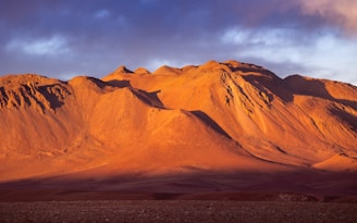 A mountain range with a cloudy sky in the background