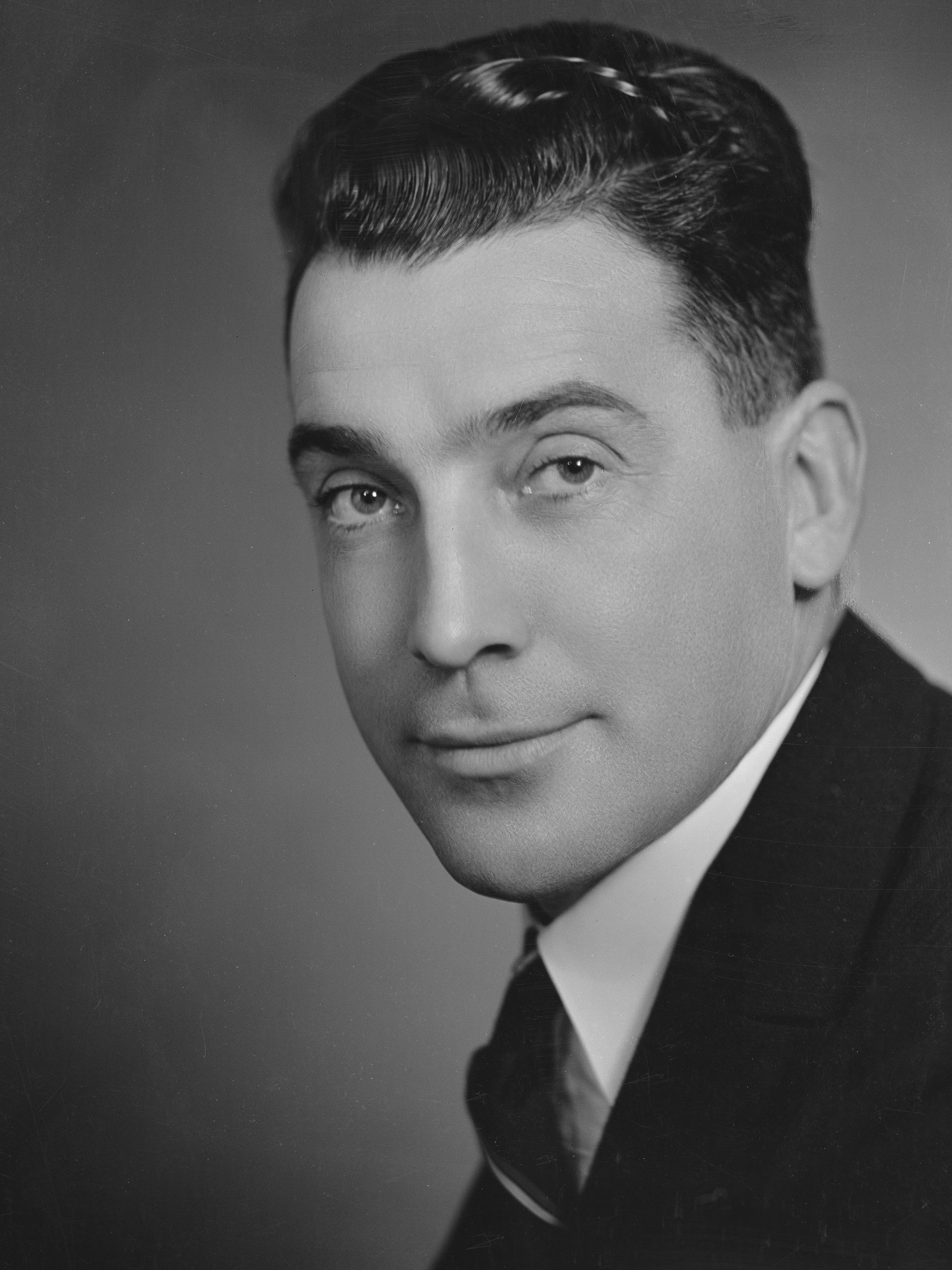 男性の白黒スタジオ肖像画です。