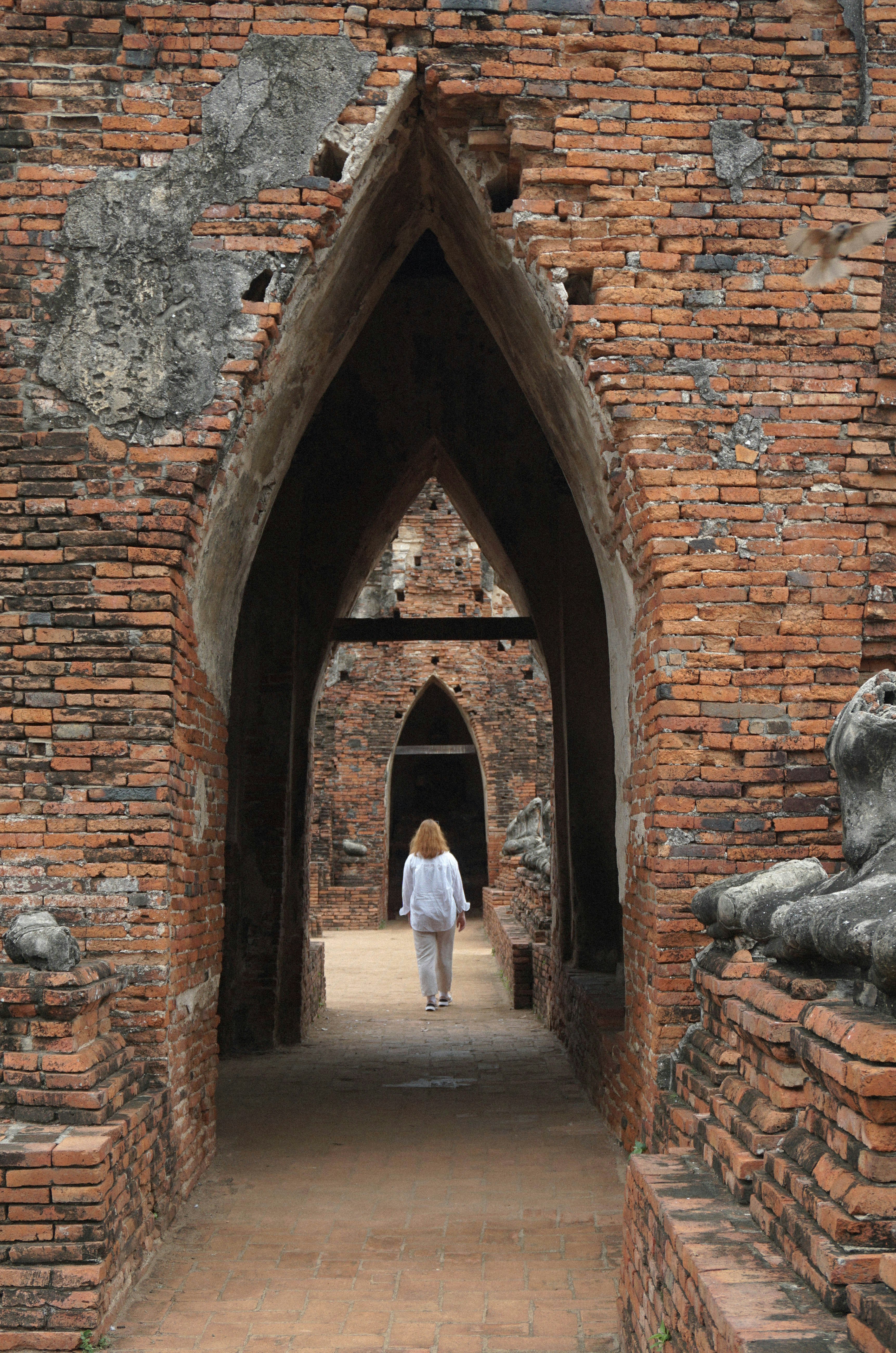 A person walking through a tunnel in a brick building