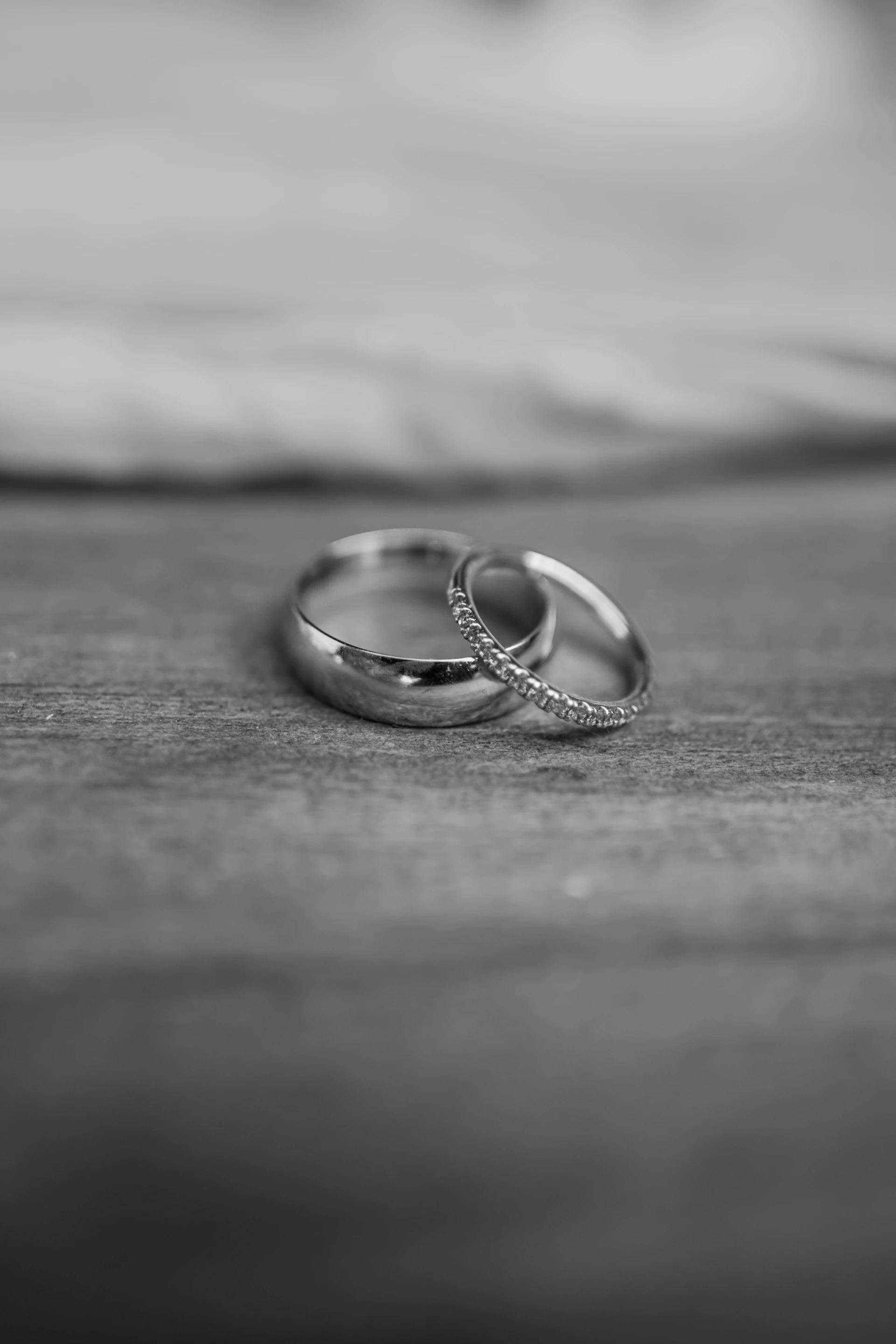 A couple of wedding rings sitting on top of a bed