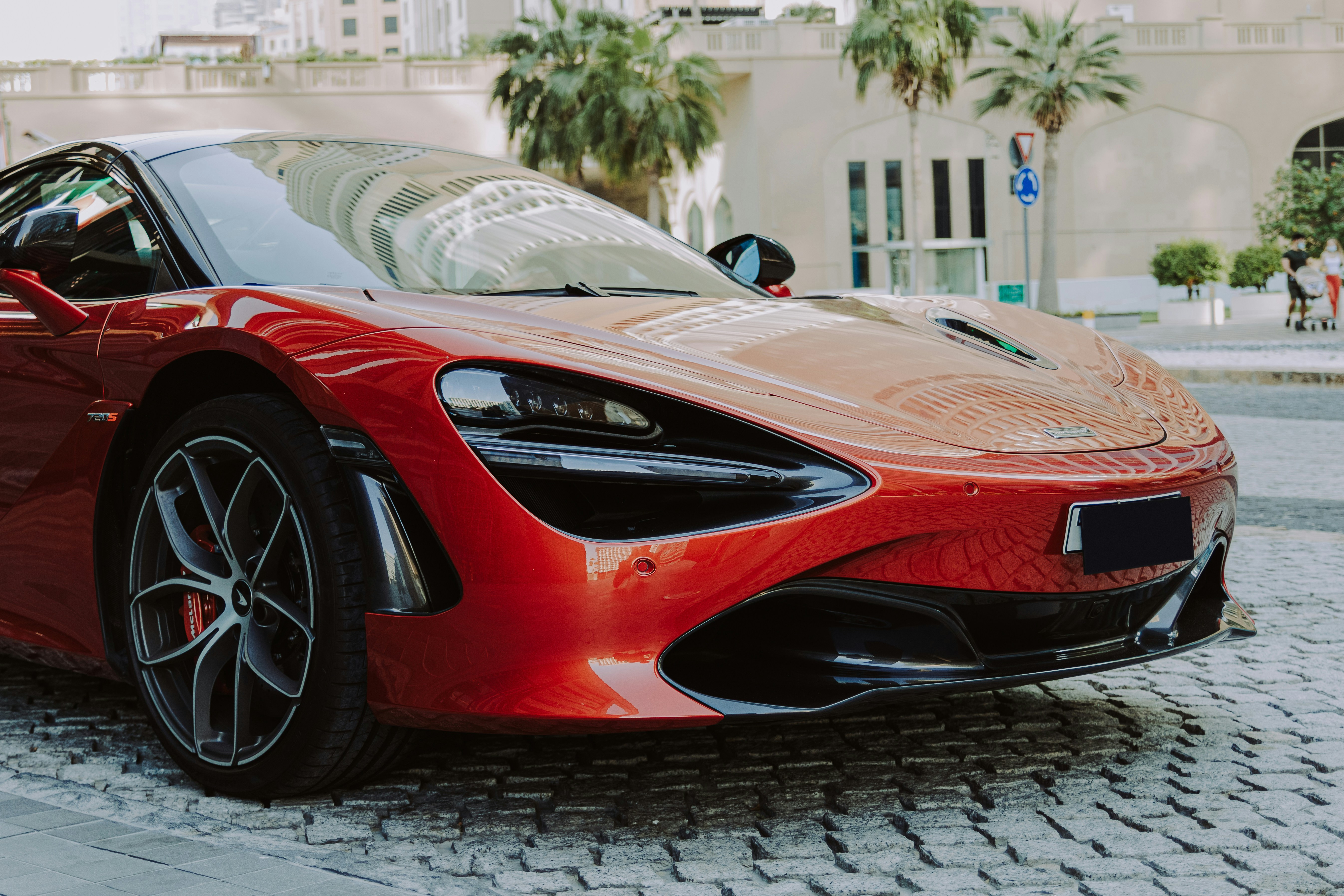 A red sports car parked on a cobblestone street