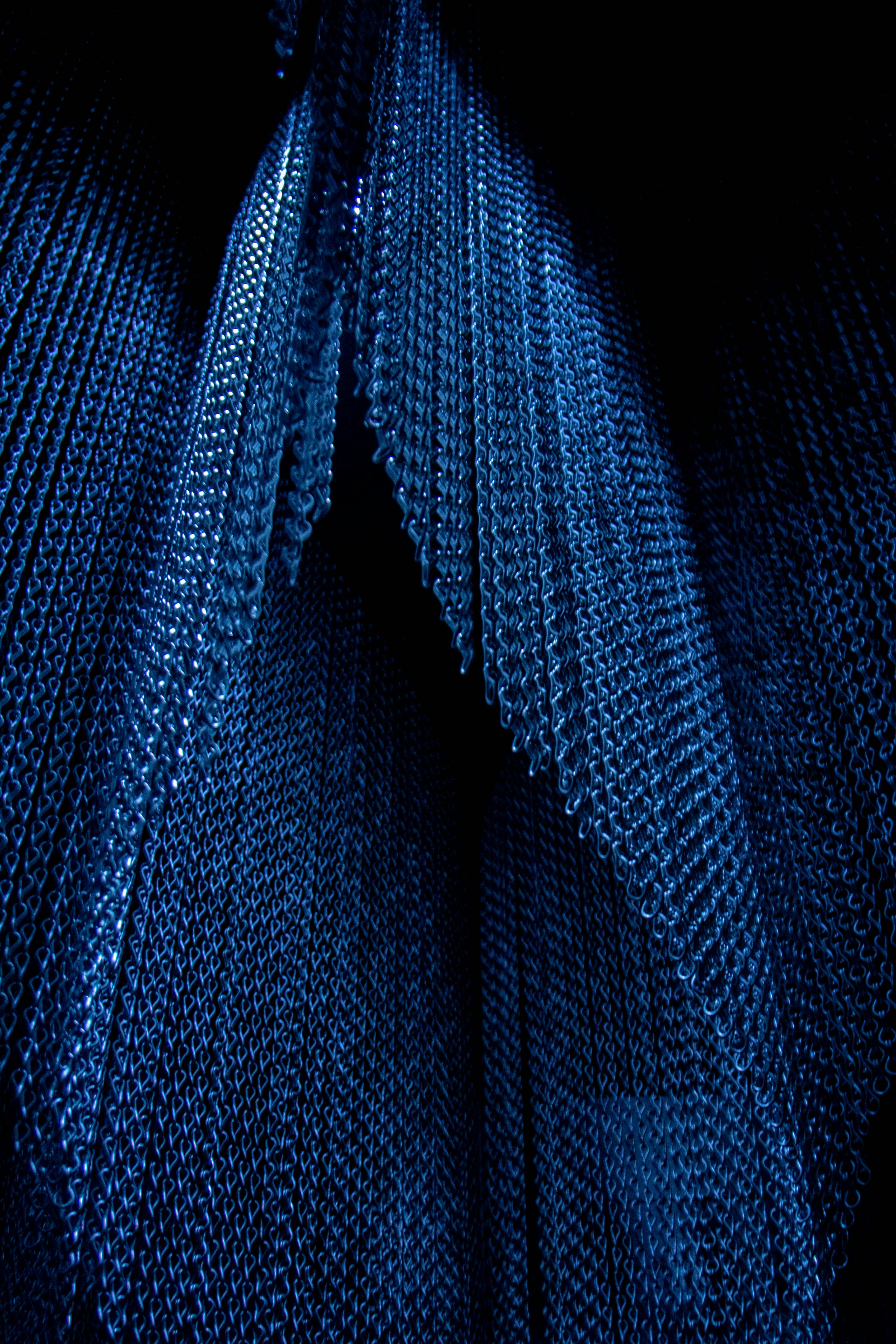 Eine Nahaufnahme einer blauen Krawatte auf schwarzem Hintergrund