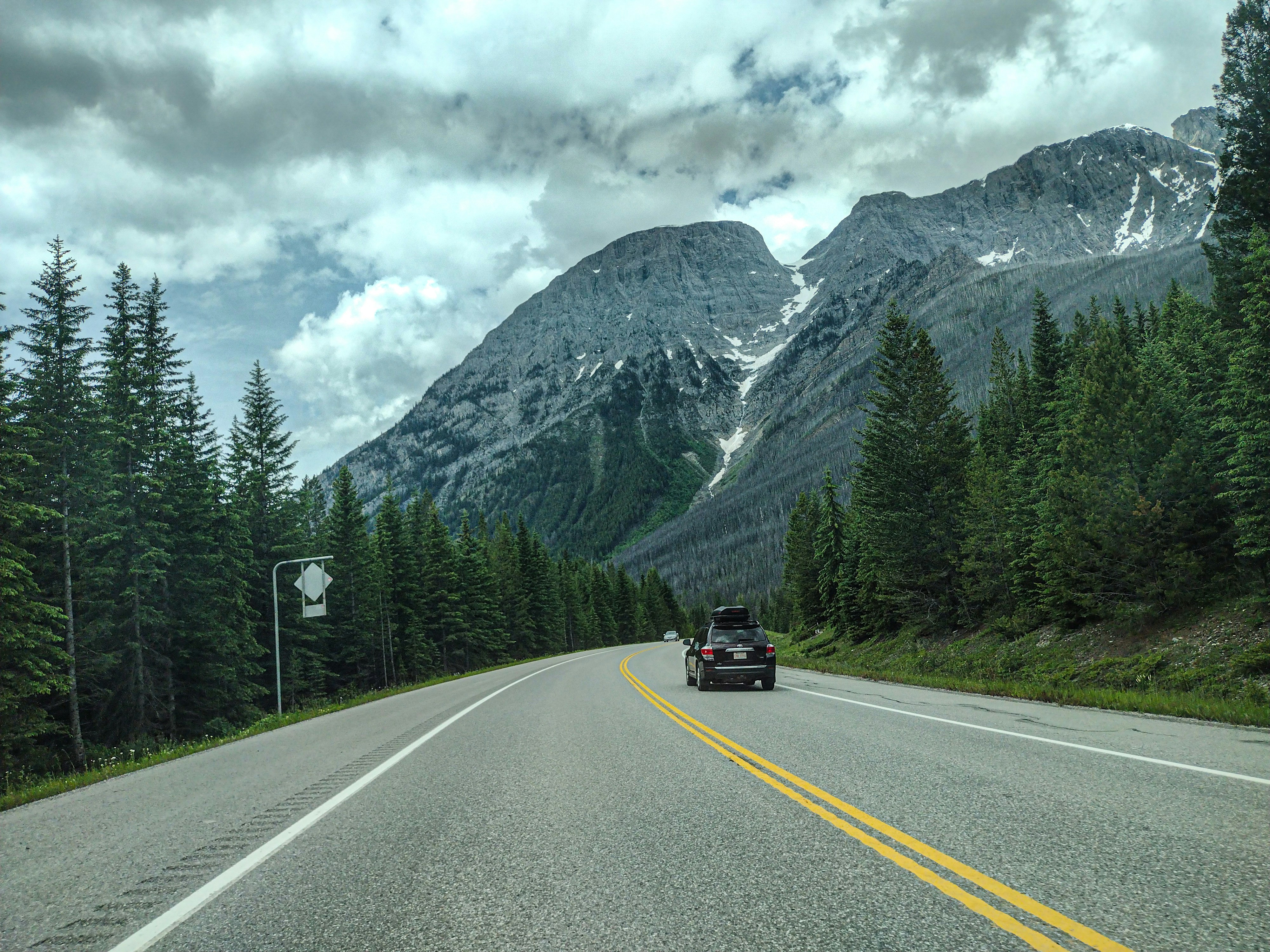 山をバックに道路を走る車