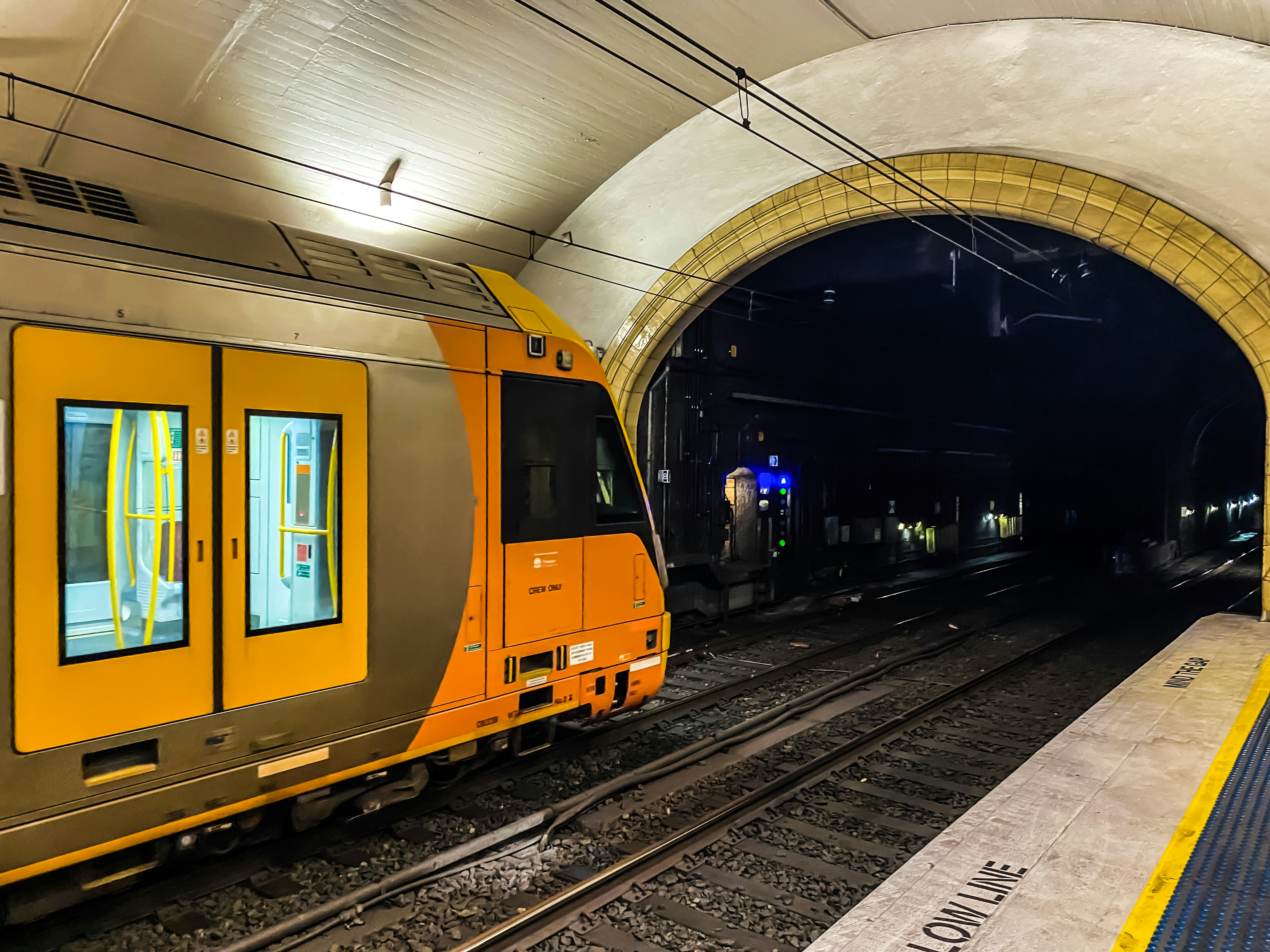A yellow train pulling into a train station