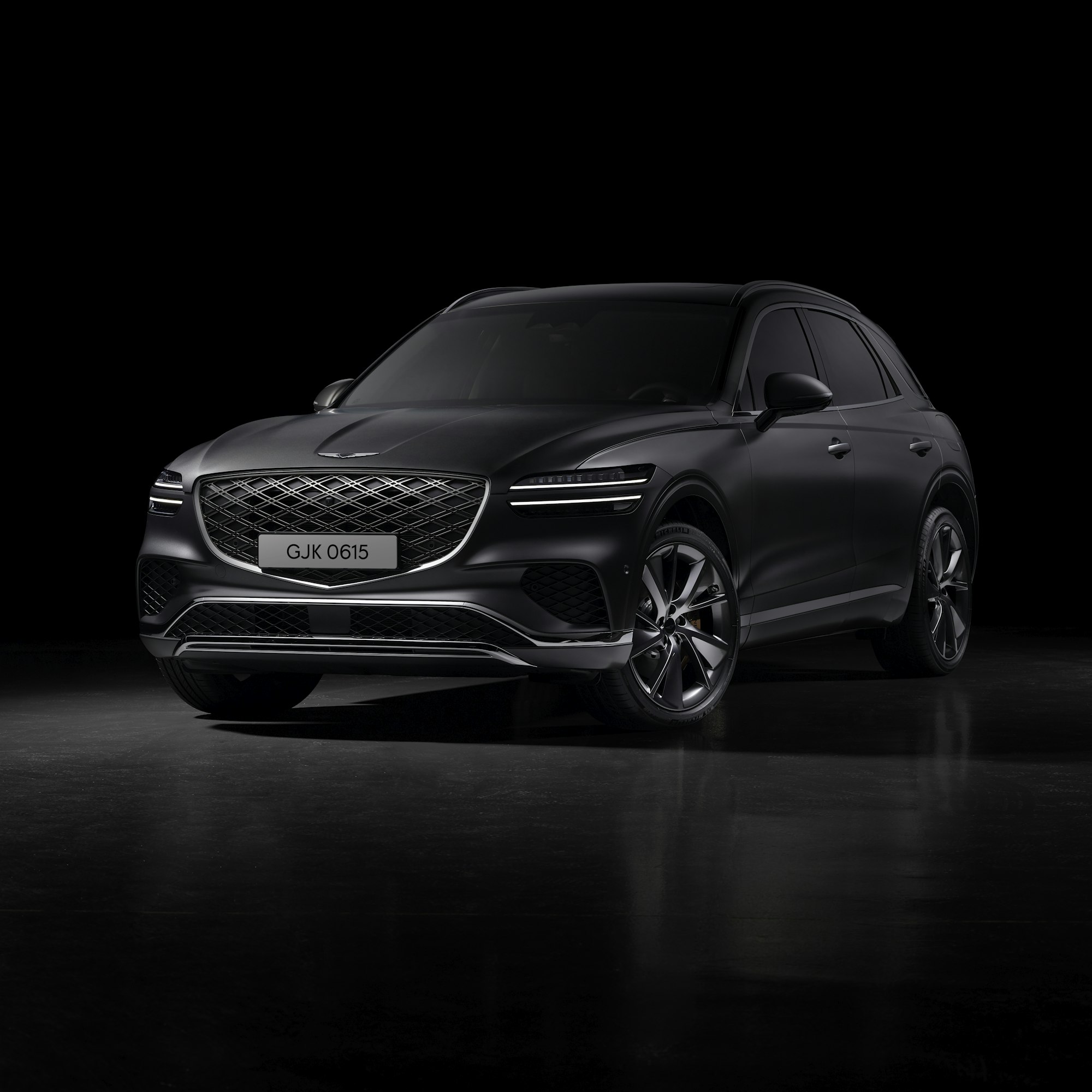 A dark luxury SUV in a black studio
