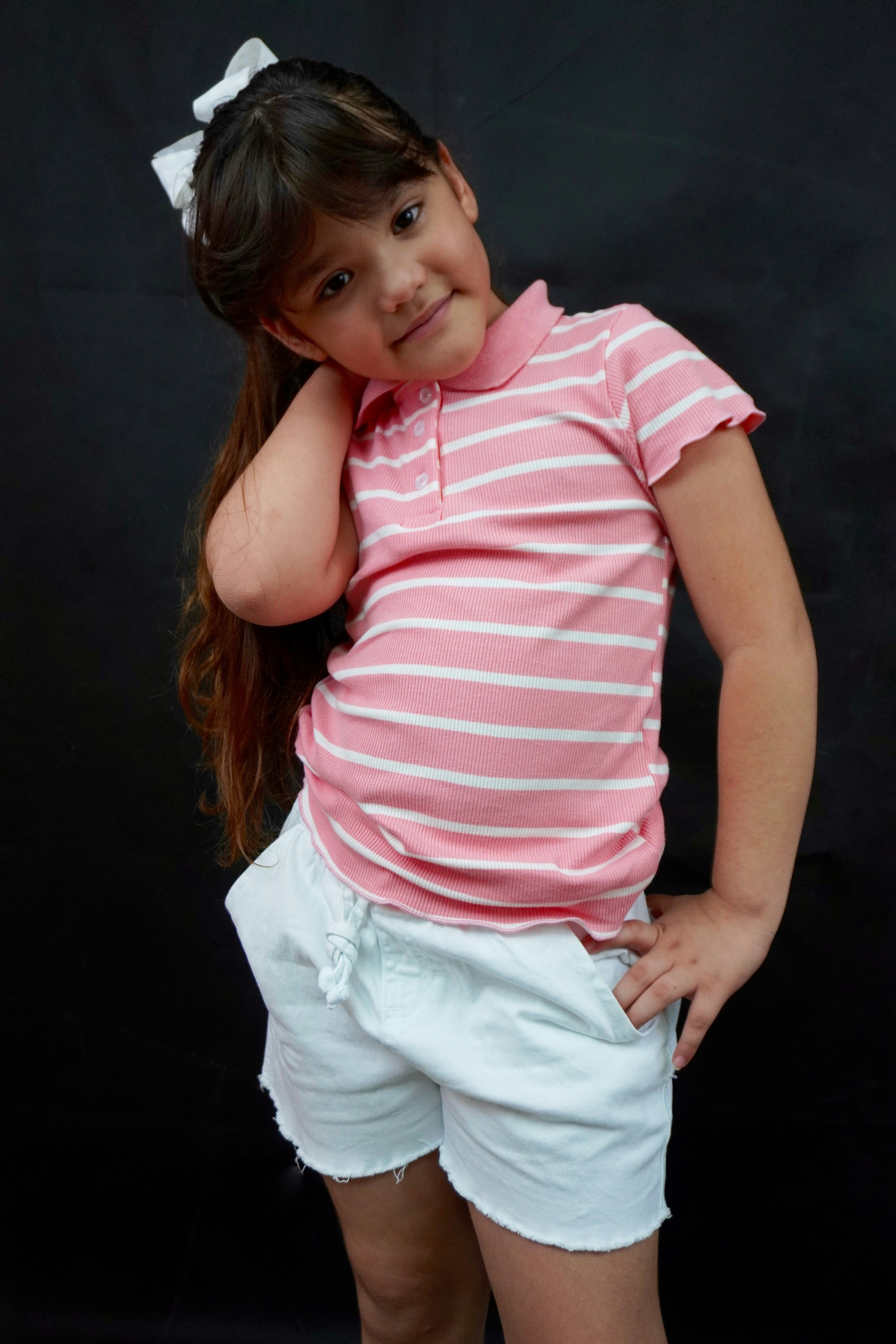 분홍색 셔츠와 흰색 반바지를 입은 어린 소녀