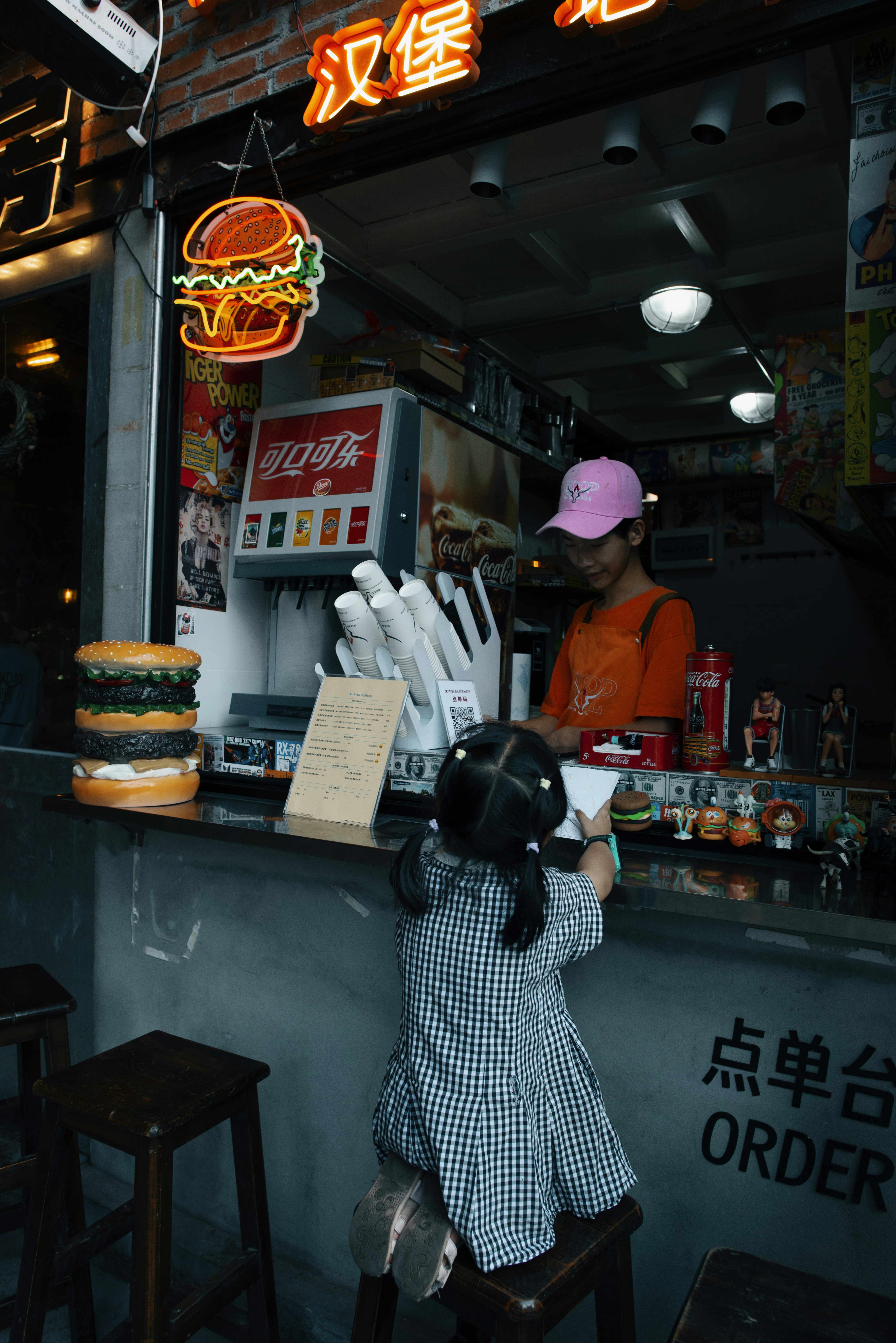 A little girl standing in front of a fast food restaurant