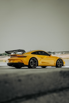 A yellow sports car driving on a track
