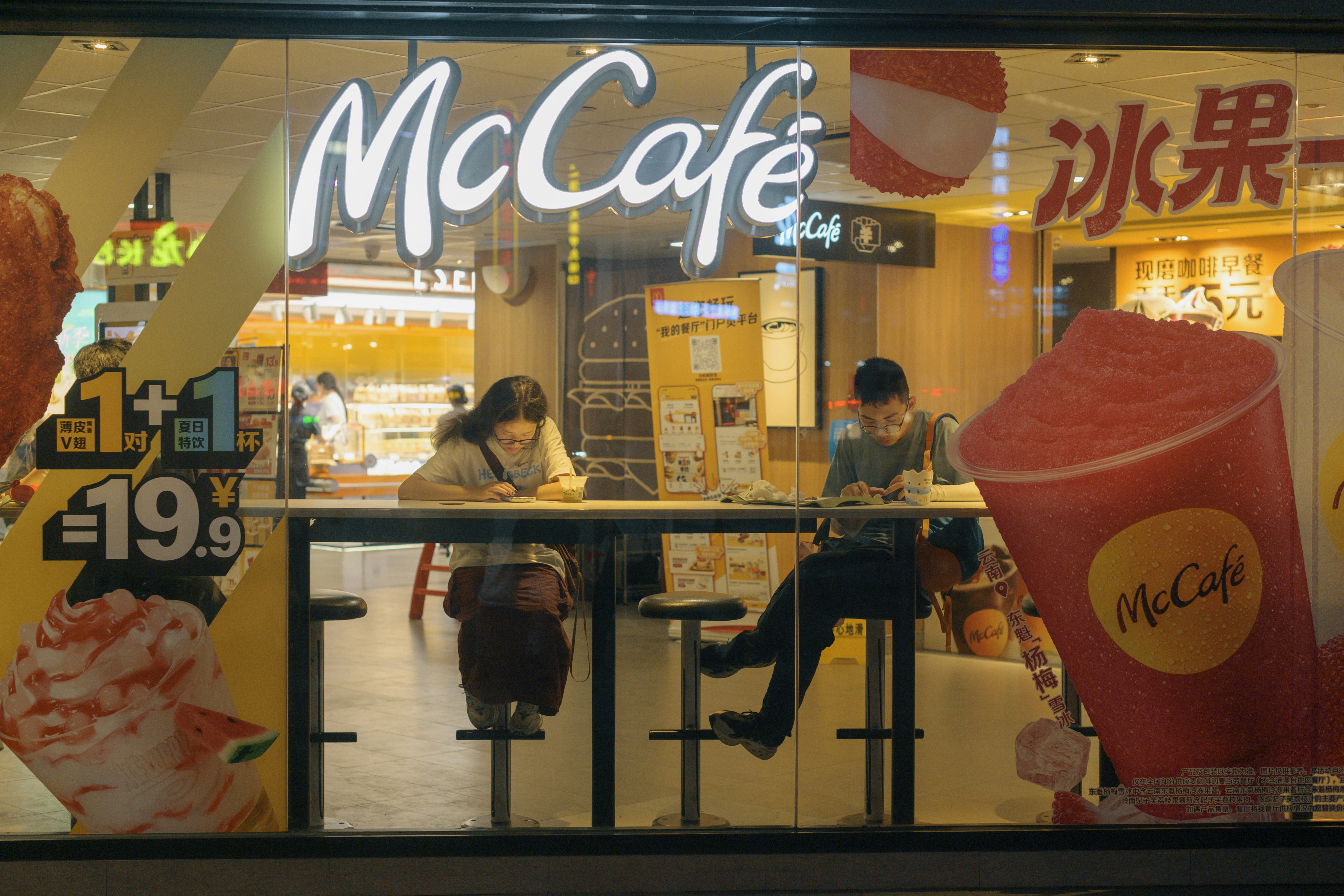 A mcdonald's restaurant with a woman sitting at a table