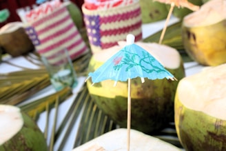 A table topped with lots of coconuts covered in umbrellas