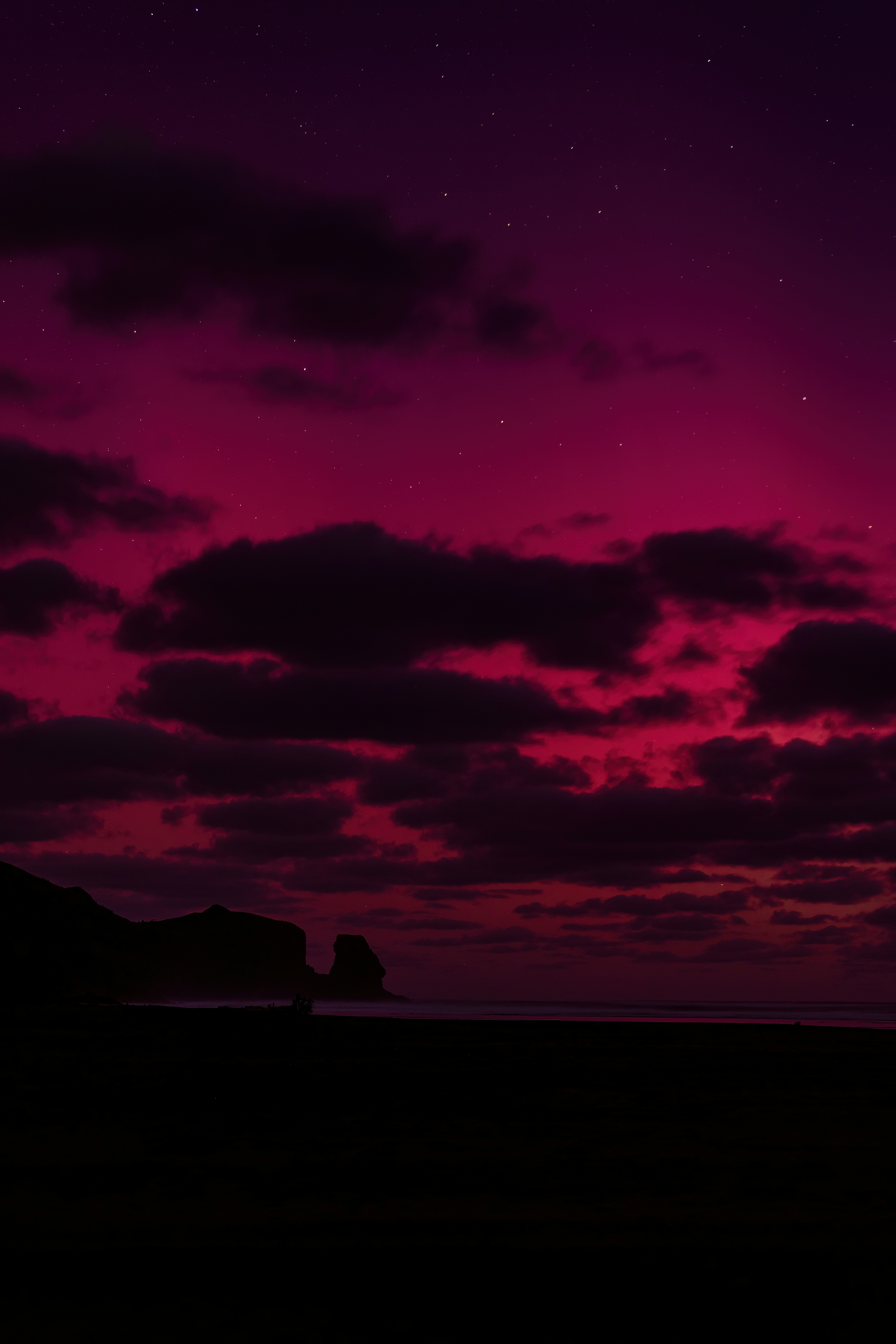 A red sky filled with clouds and stars