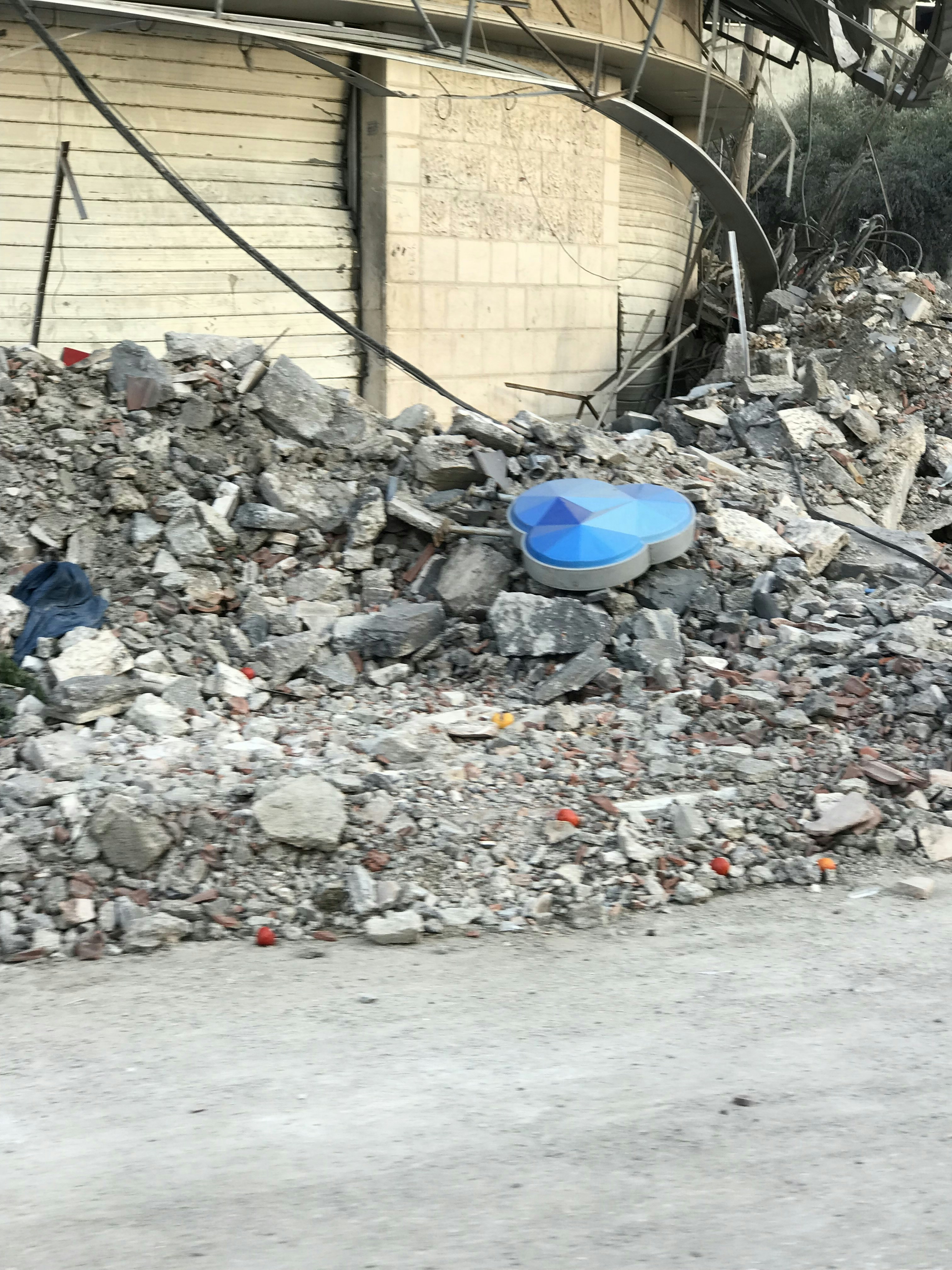 A blue frisbee sitting on top of a pile of rubble