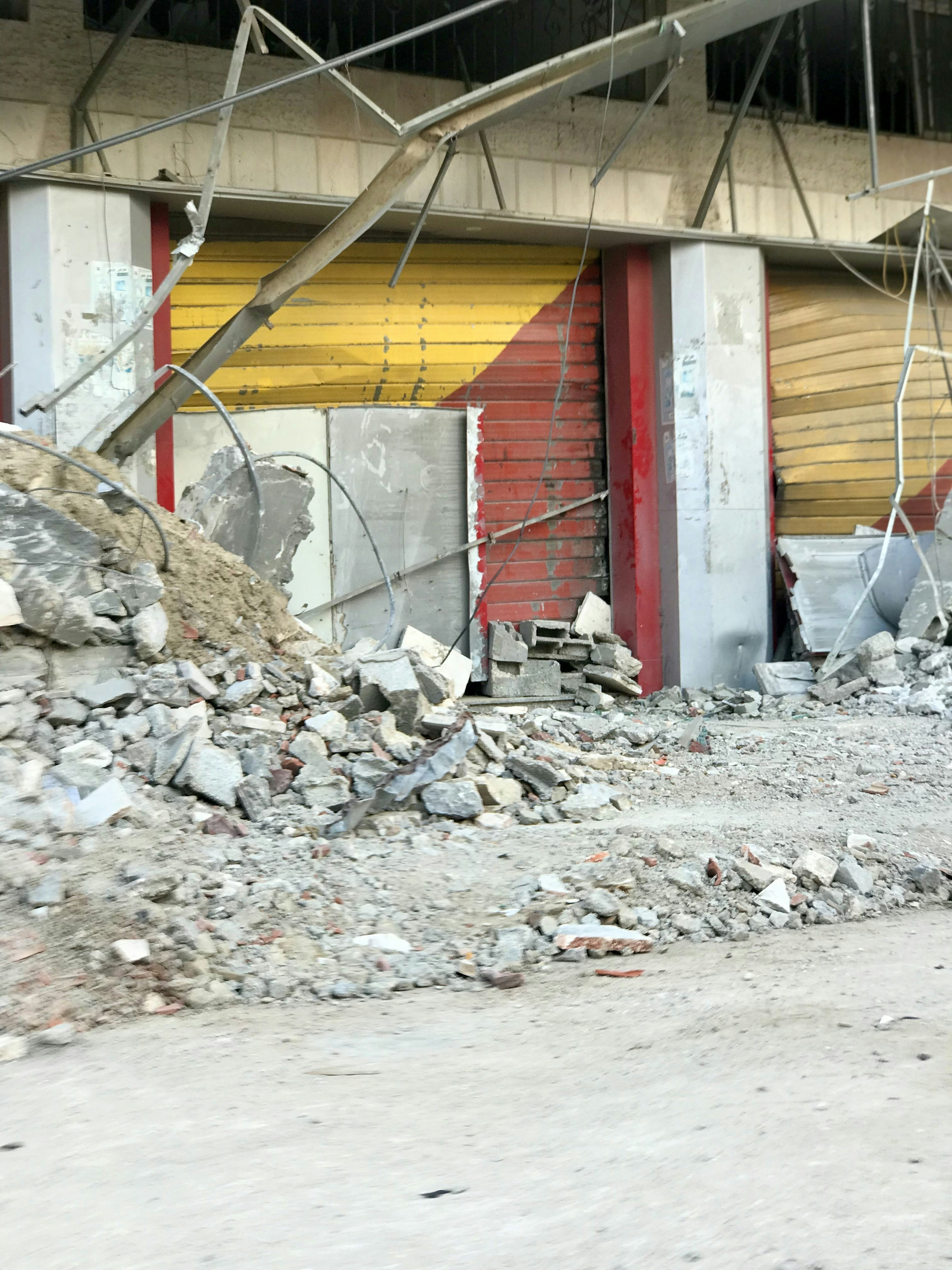 A red fire hydrant sitting next to a pile of rubble