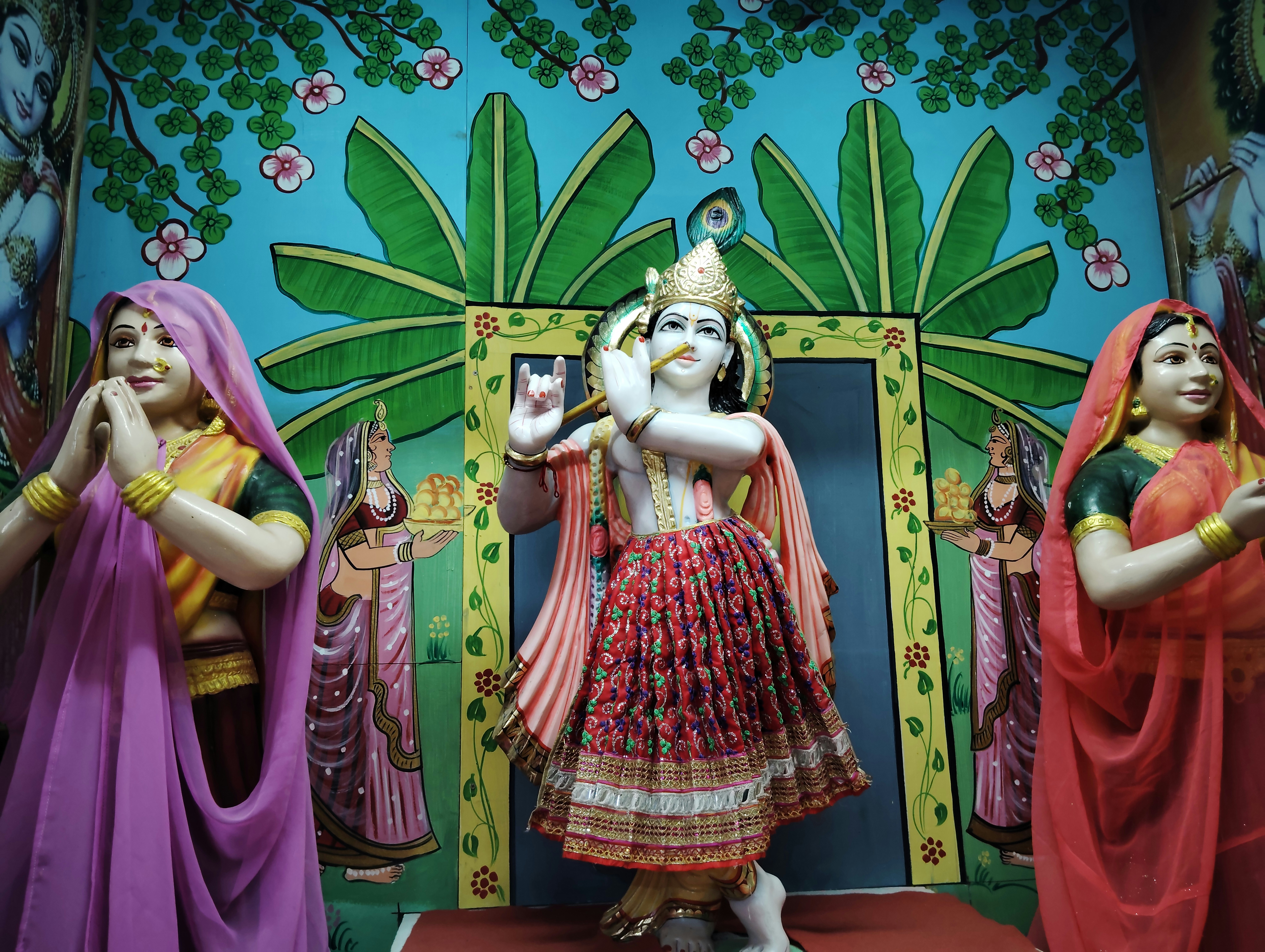 A group of statues of people standing in front of a wall