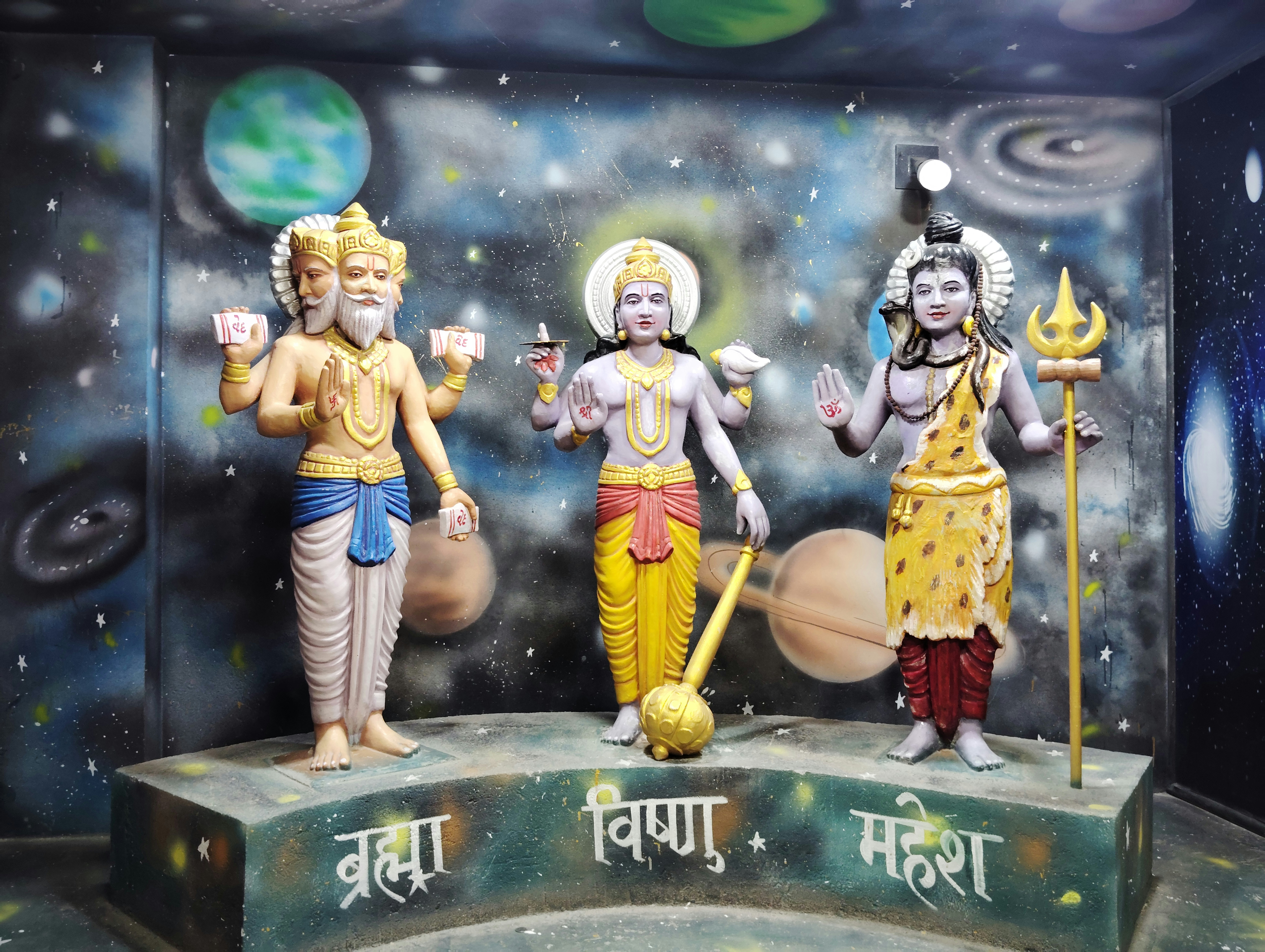Three statues of hindu deities on a stage