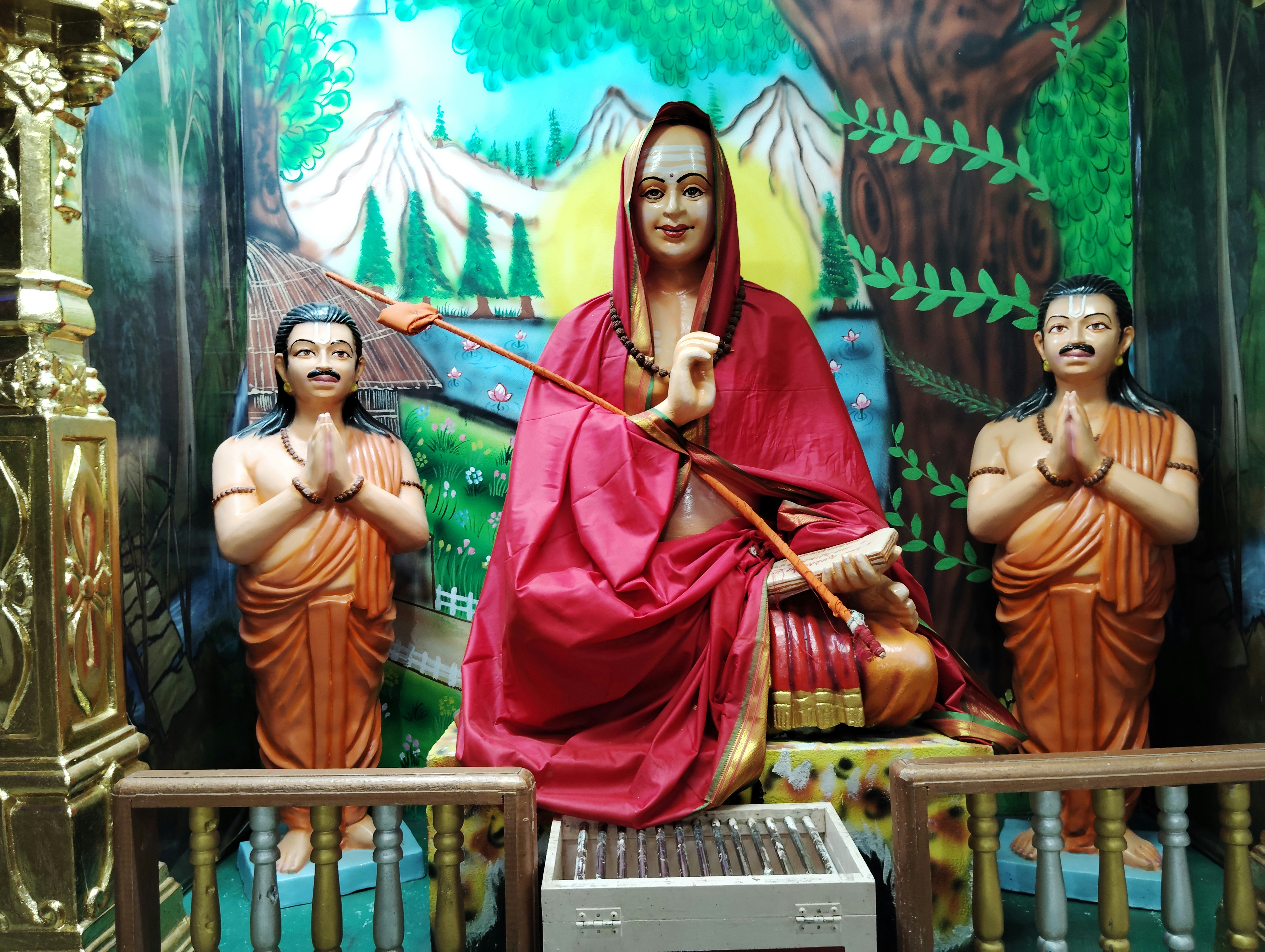 A statue of a woman sitting in front of a painting