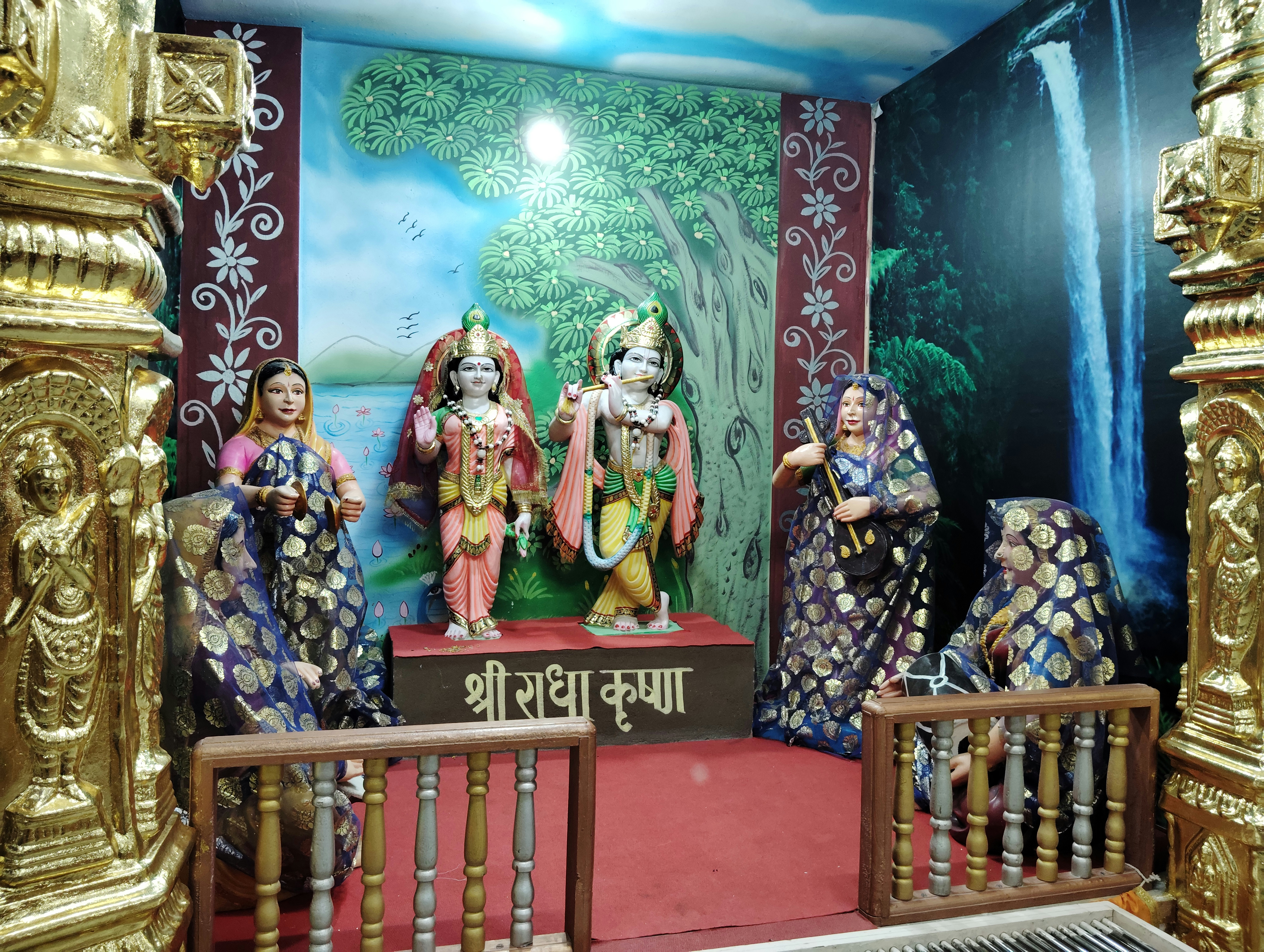 A group of statues sitting on top of a wooden bench
