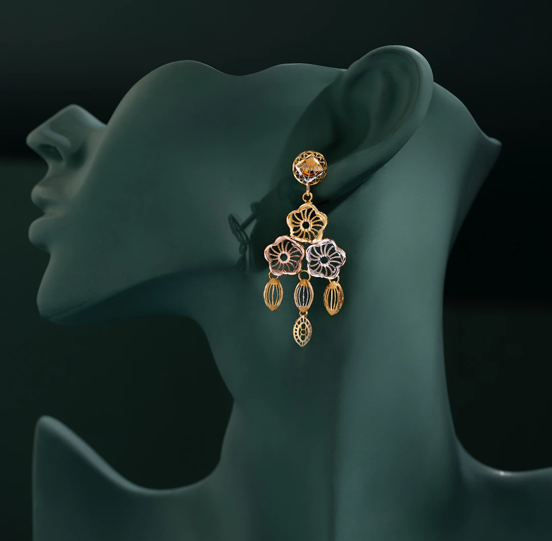 Mulher de perfil usando brinco dourado com pérola.