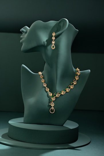 A green mannequin with a necklace on it