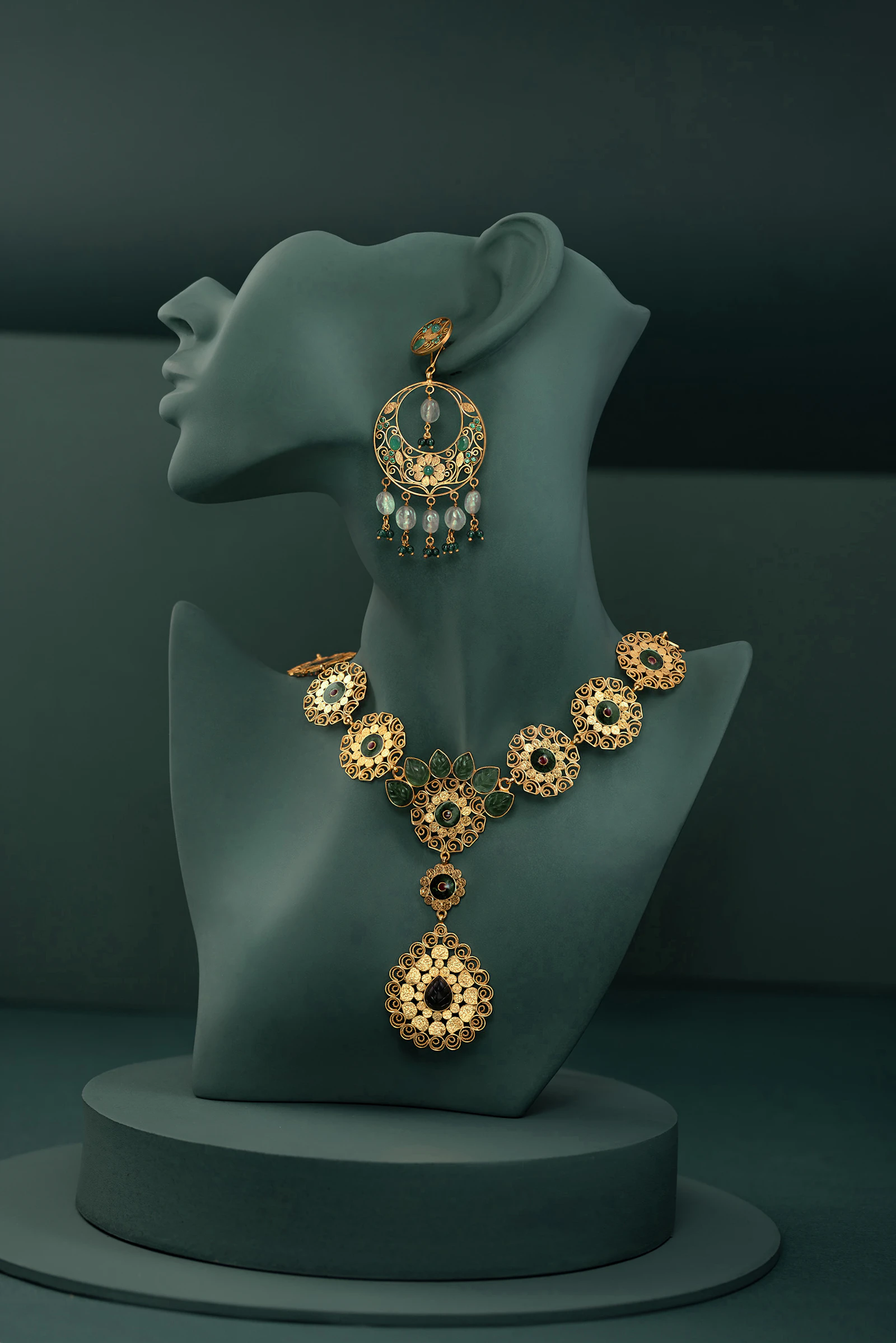 Close-up of a woman wearing a delicate gold necklace and matching earrings