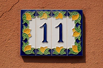 A blue and yellow house number 11 on a wall
