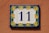 A blue and yellow house number 11 on a wall