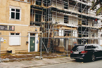 A car parked in front of a building under construction