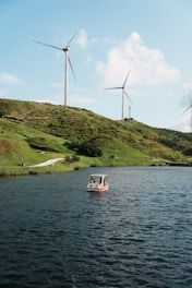 A small boat in a body of water near wind turbines