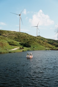A small boat in a body of water near wind turbines