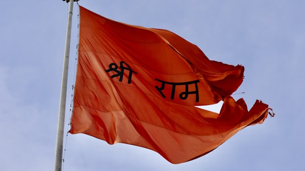 A red flag flying in the wind with a sky background