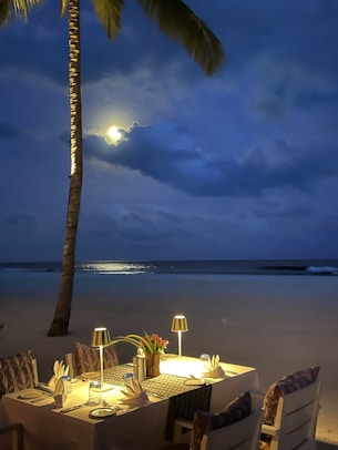 A table set up on the beach with a full moon in the background