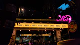A neon sign on a bar front