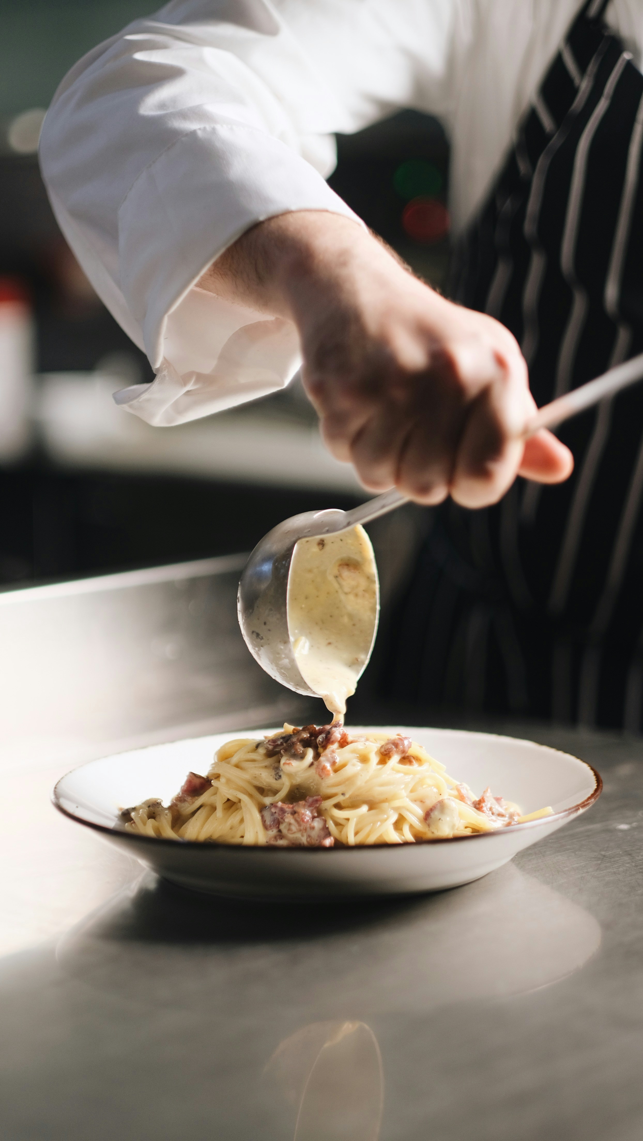 A person in a kitchen preparing food on a plate