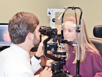 A man and a woman looking through a camera