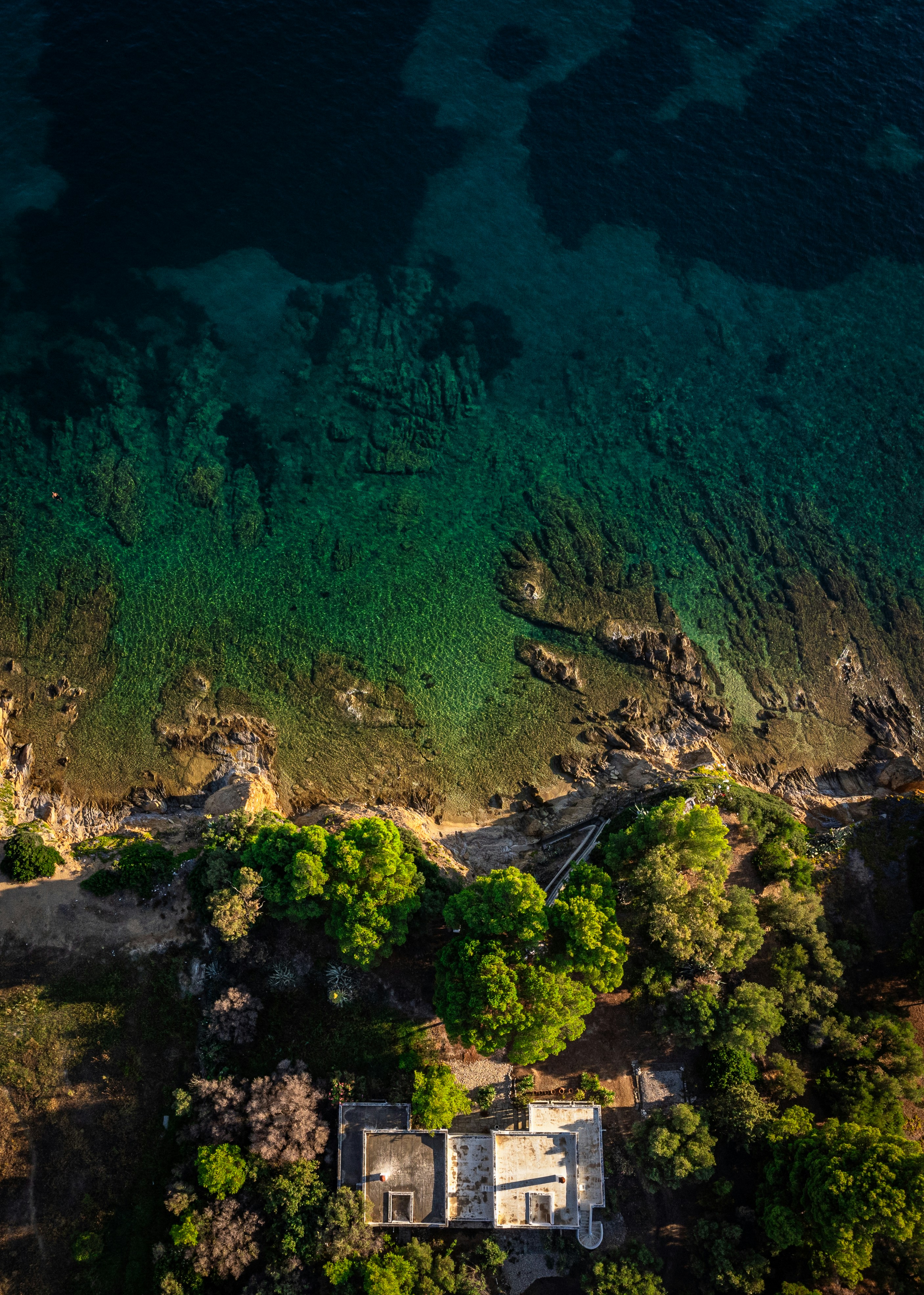 An aerial view of a house on the shore of a lake