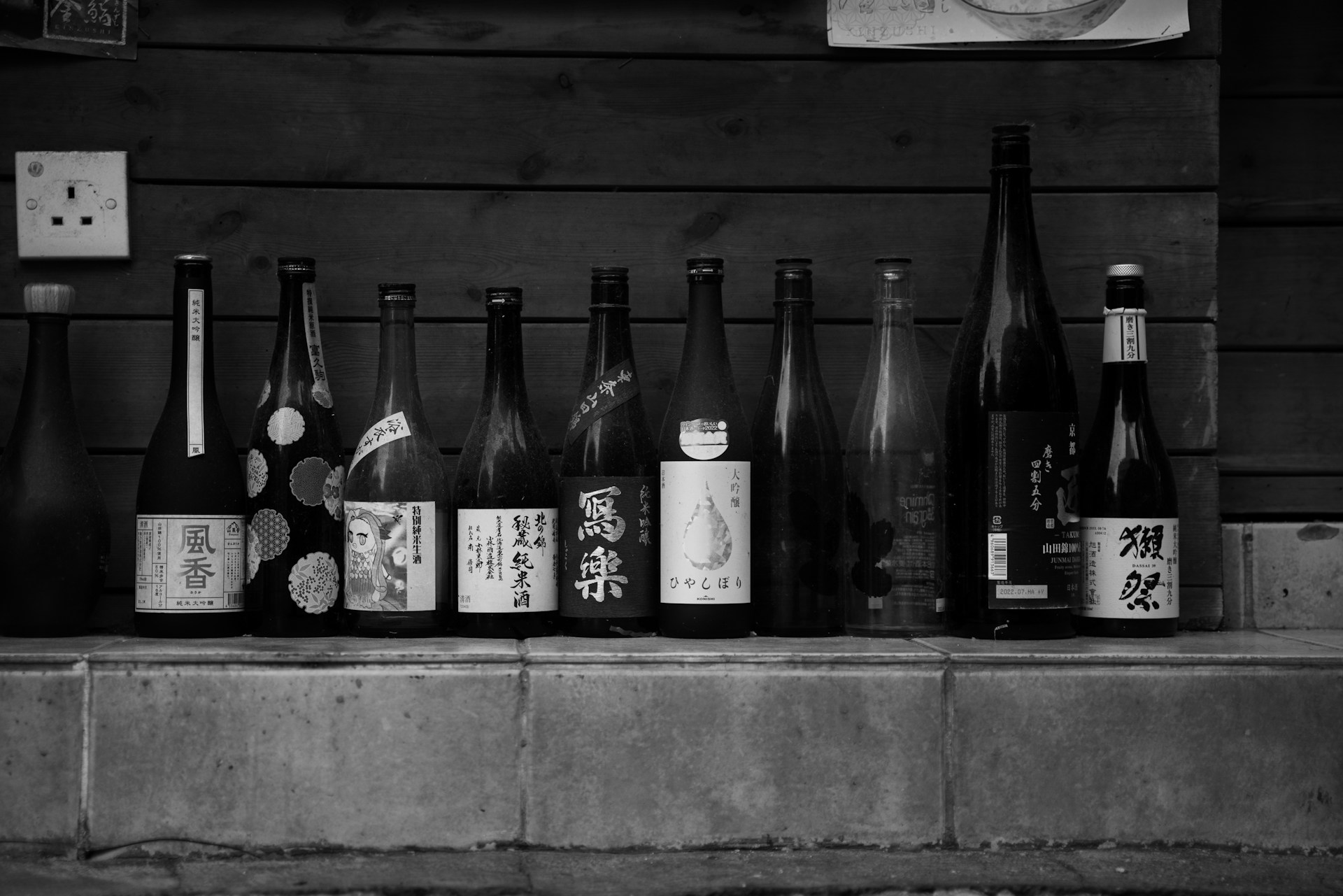 A black and white photo of bottles of wine