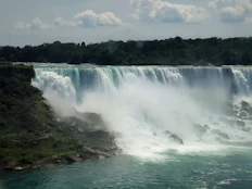 A view of a waterfall from a boat on the water