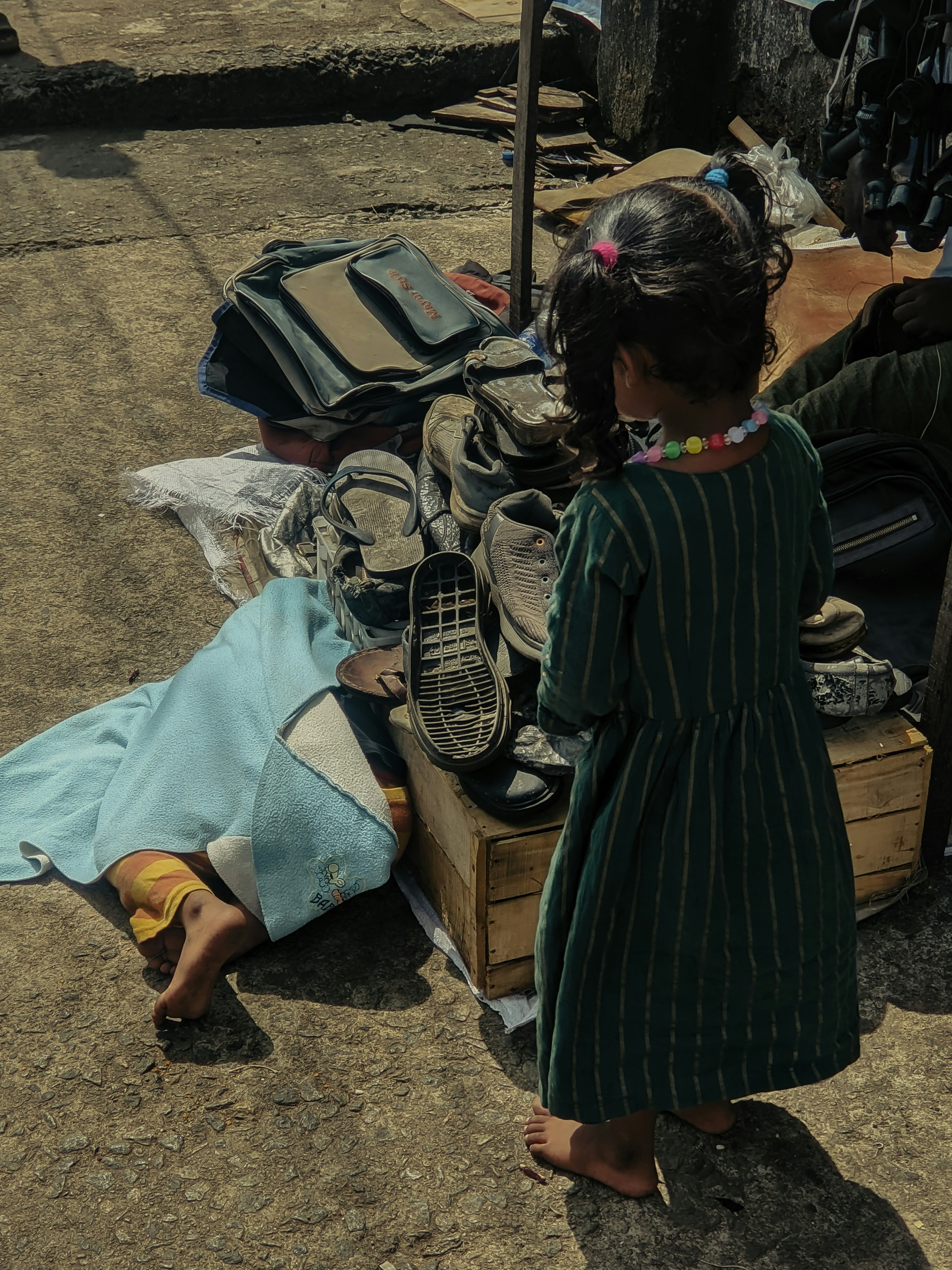 A little girl standing next to a pile of luggage