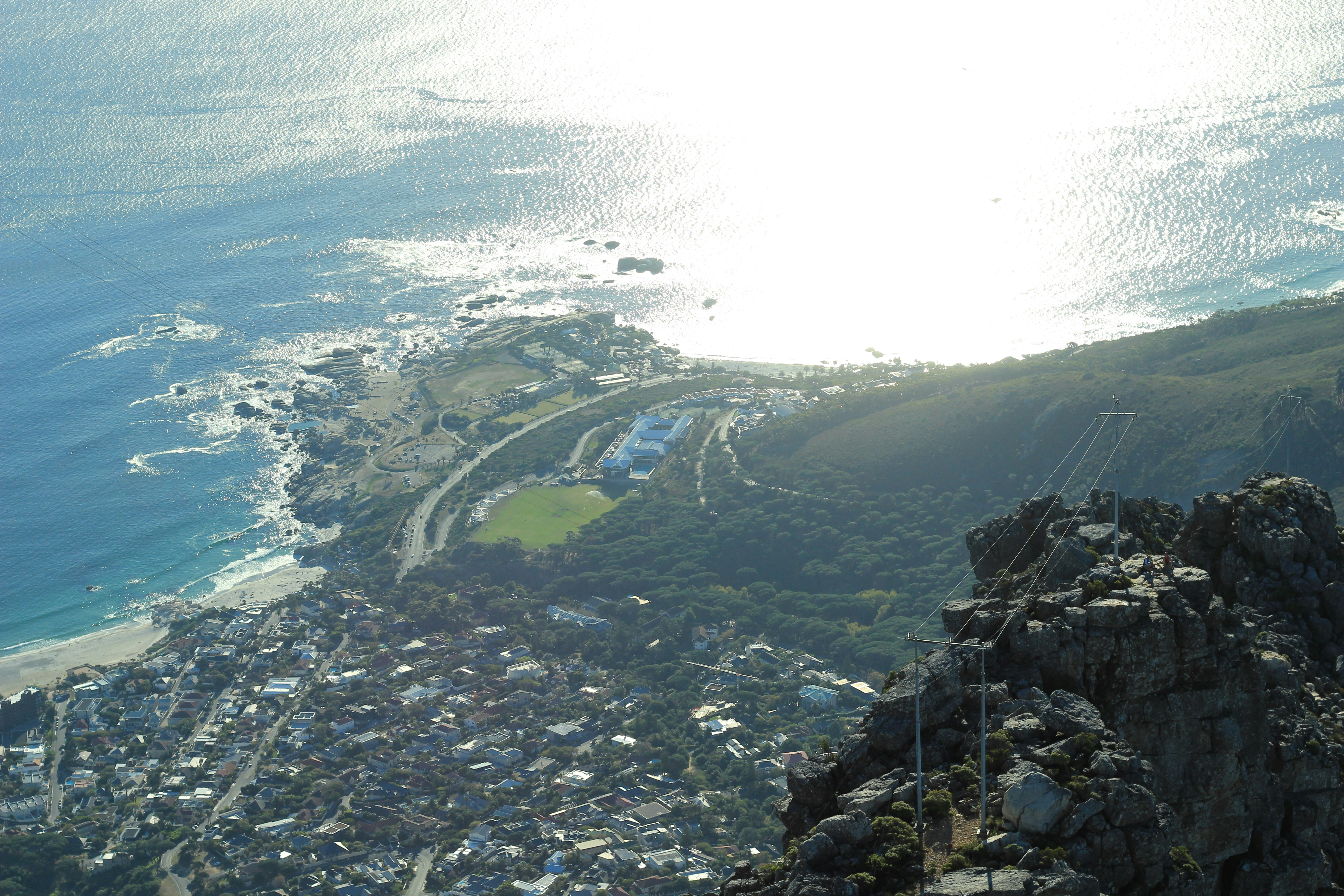 A man standing on top of a mountain next to the ocean